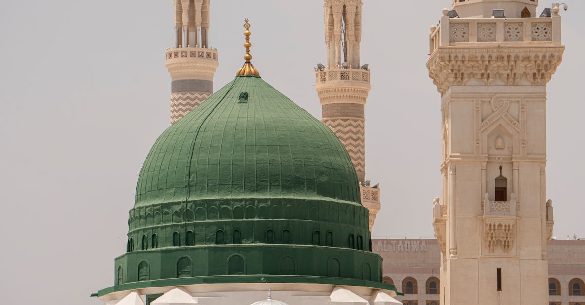 The iconic Green Dome of Al-Masjid an-Nabawi in Medina, Saudi Arabia, with surrounding minarets.